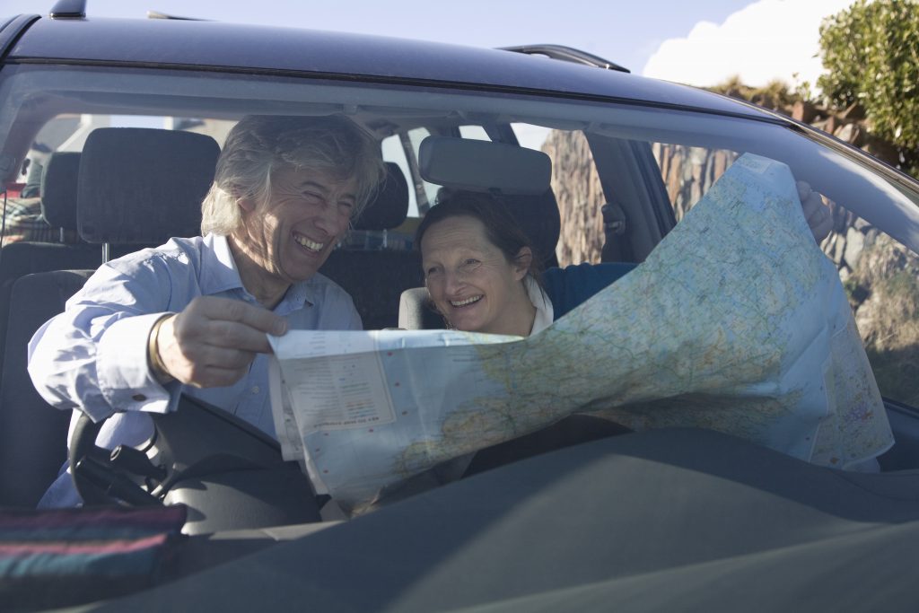 Starší pár v aute s mapou.
